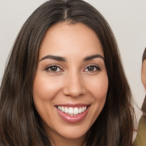 Joyful white young-adult female with long  brown hair and brown eyes