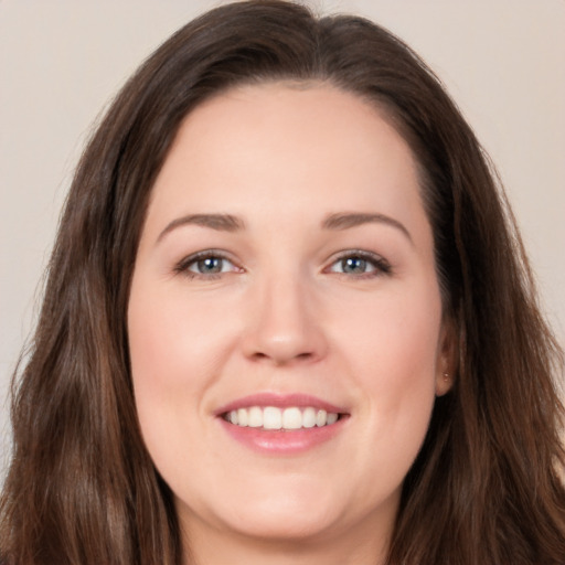 Joyful white young-adult female with long  brown hair and brown eyes