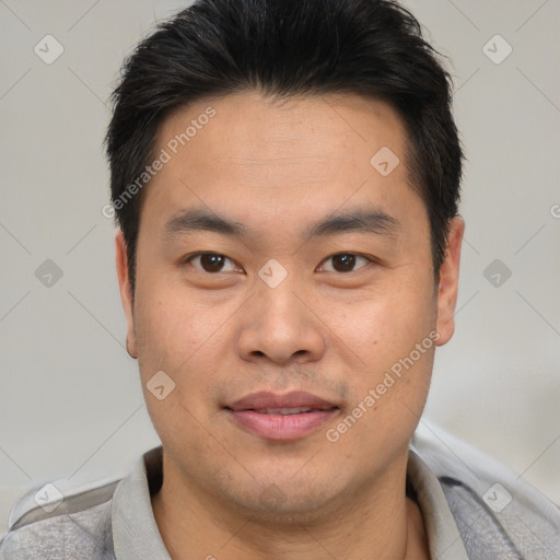 Joyful asian young-adult male with short  brown hair and brown eyes