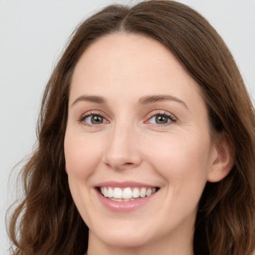 Joyful white young-adult female with long  brown hair and green eyes