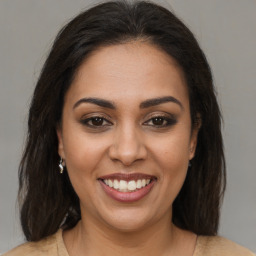 Joyful latino young-adult female with medium  brown hair and brown eyes