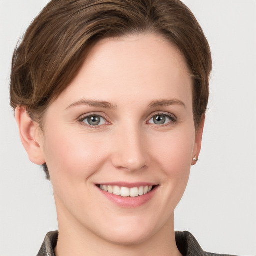 Joyful white young-adult female with short  brown hair and grey eyes