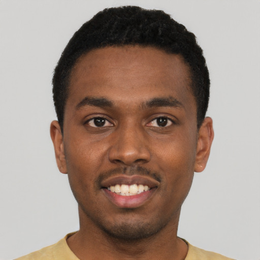 Joyful black young-adult male with short  black hair and brown eyes