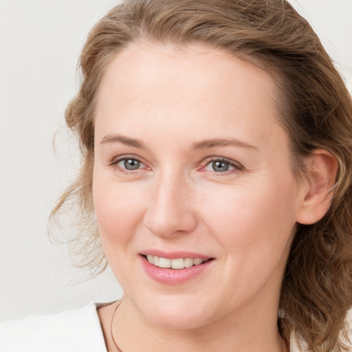 Joyful white young-adult female with long  brown hair and blue eyes