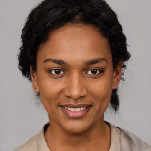 Joyful black young-adult female with short  black hair and brown eyes