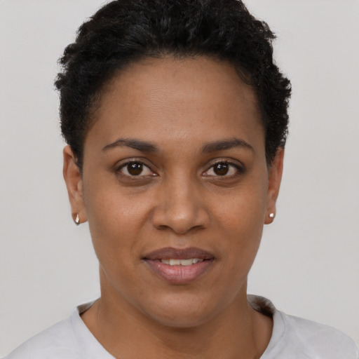 Joyful black young-adult female with short  brown hair and brown eyes