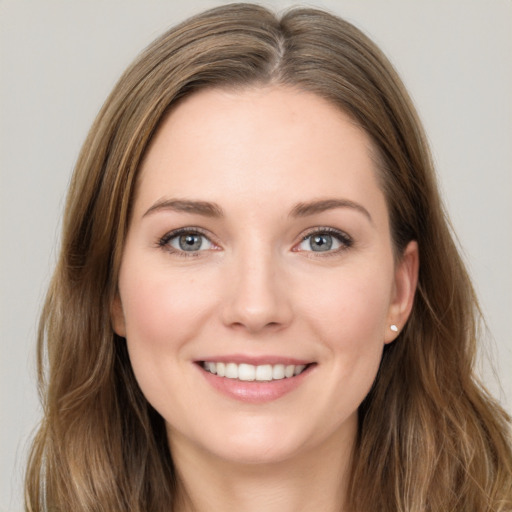 Joyful white young-adult female with long  brown hair and green eyes