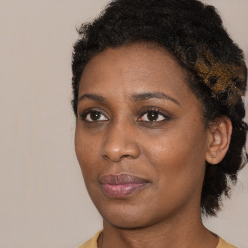 Joyful black young-adult female with medium  brown hair and brown eyes