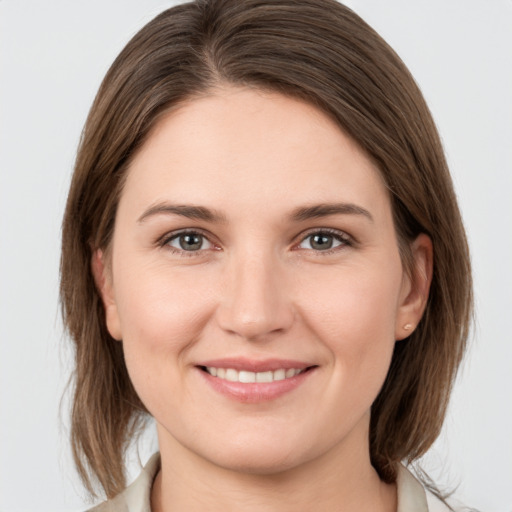 Joyful white young-adult female with medium  brown hair and grey eyes