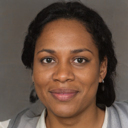 Joyful black adult female with medium  brown hair and brown eyes