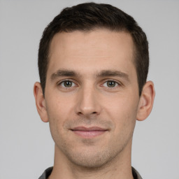 Joyful white young-adult male with short  brown hair and grey eyes