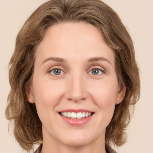 Joyful white young-adult female with medium  brown hair and grey eyes