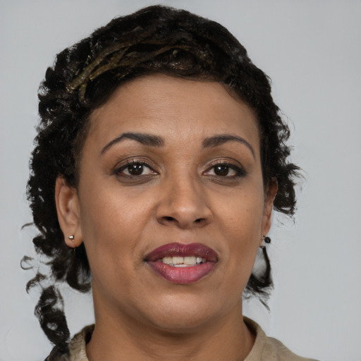 Joyful black adult female with long  brown hair and brown eyes