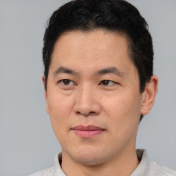 Joyful asian adult male with short  brown hair and brown eyes