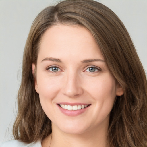 Joyful white young-adult female with long  brown hair and grey eyes