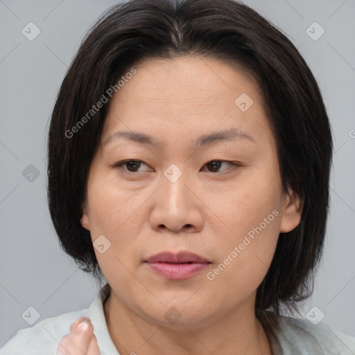 Joyful asian adult female with medium  brown hair and brown eyes