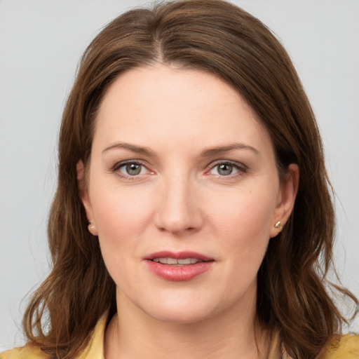 Joyful white young-adult female with medium  brown hair and grey eyes