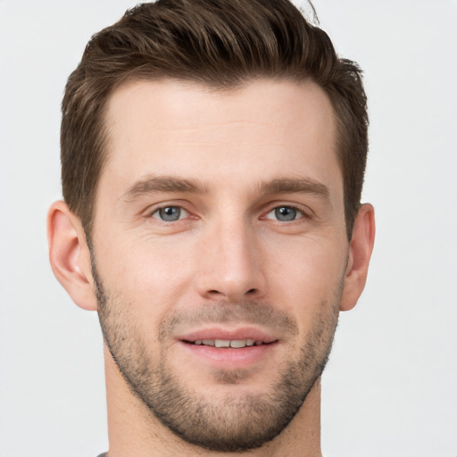 Joyful white young-adult male with short  brown hair and grey eyes