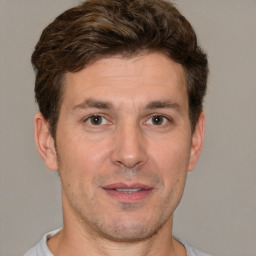 Joyful white adult male with short  brown hair and brown eyes