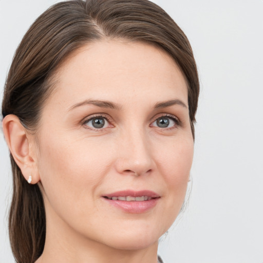 Joyful white young-adult female with medium  brown hair and grey eyes