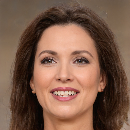 Joyful white adult female with long  brown hair and brown eyes