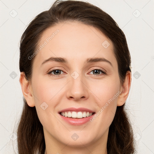 Joyful white young-adult female with long  brown hair and grey eyes