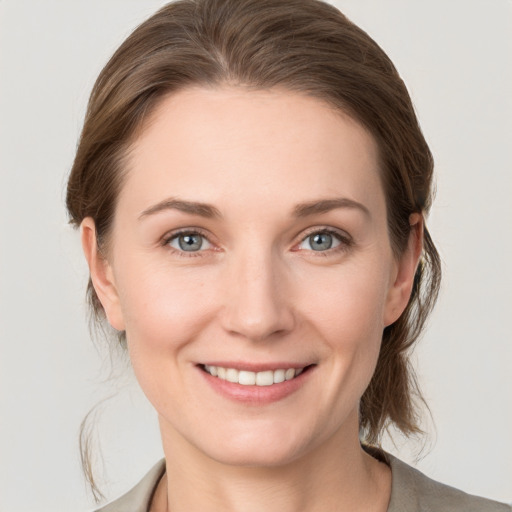 Joyful white young-adult female with medium  brown hair and grey eyes