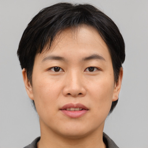 Joyful asian young-adult male with short  black hair and brown eyes