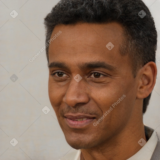 Joyful black adult male with short  black hair and brown eyes