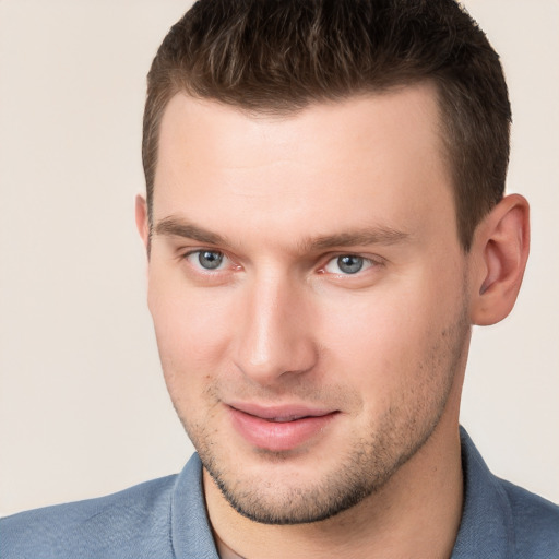 Joyful white young-adult male with short  brown hair and grey eyes