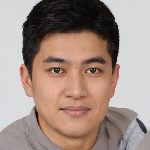 Joyful asian young-adult male with short  brown hair and brown eyes
