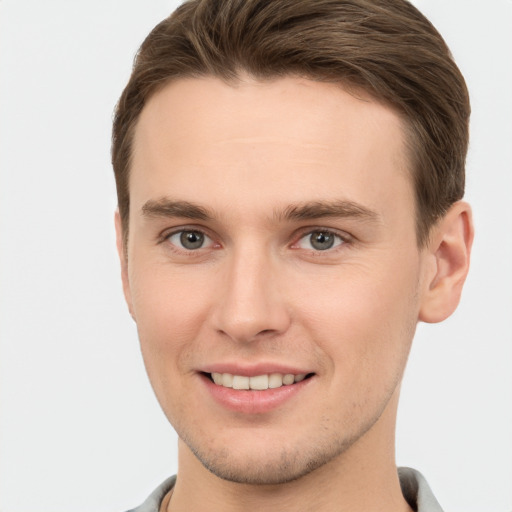 Joyful white young-adult male with short  brown hair and grey eyes