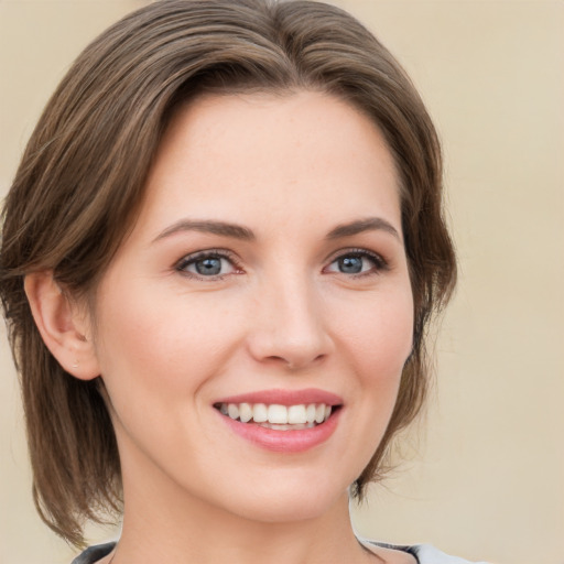 Joyful white young-adult female with medium  brown hair and green eyes