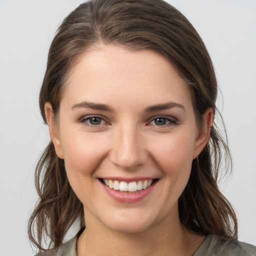 Joyful white young-adult female with medium  brown hair and grey eyes