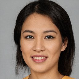 Joyful latino young-adult female with medium  brown hair and brown eyes