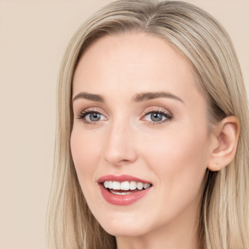 Joyful white young-adult female with long  brown hair and blue eyes