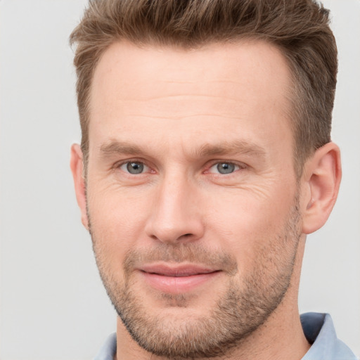 Joyful white adult male with short  brown hair and brown eyes