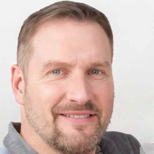 Joyful white adult male with short  brown hair and blue eyes