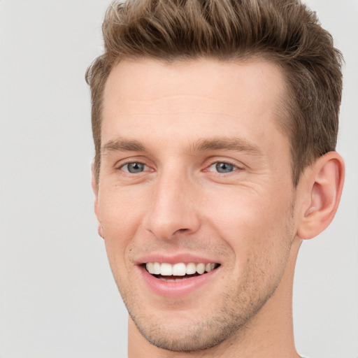 Joyful white young-adult male with short  brown hair and grey eyes