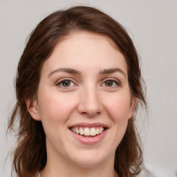 Joyful white young-adult female with medium  brown hair and green eyes