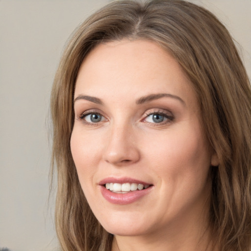 Joyful white young-adult female with long  brown hair and green eyes