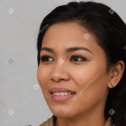 Joyful latino young-adult female with long  brown hair and brown eyes