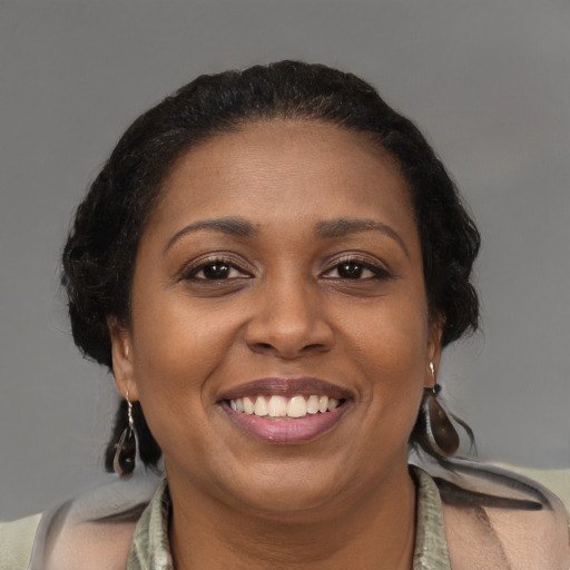 Joyful black young-adult female with medium  brown hair and brown eyes