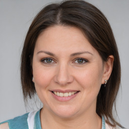 Joyful white adult female with medium  brown hair and blue eyes