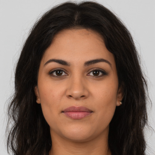Joyful latino young-adult female with long  brown hair and brown eyes