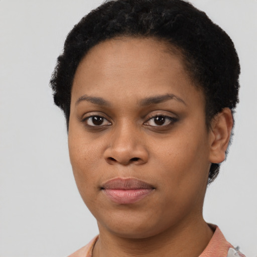 Joyful black young-adult female with short  brown hair and brown eyes