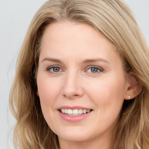 Joyful white young-adult female with long  brown hair and blue eyes