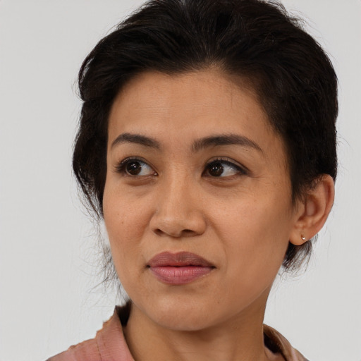 Joyful latino adult female with medium  brown hair and brown eyes