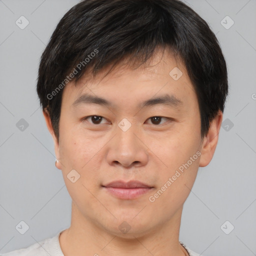 Joyful asian young-adult male with short  brown hair and brown eyes