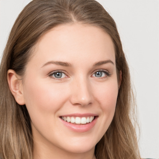 Joyful white young-adult female with long  brown hair and grey eyes